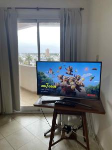 een flatscreen-tv zittend op een tafel voor een raam bij Departamento Vista Bella, céntrico y cercano a la terminal, Exc ubicación, playa estacionamiento cercana-económica in Villa María