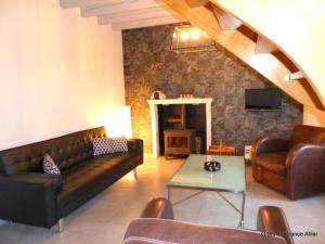 a living room with a couch and a table at Maison rénovée avec jardin, animaux acceptés, climatisation, parking - FR-1-489-36 in Agonges
