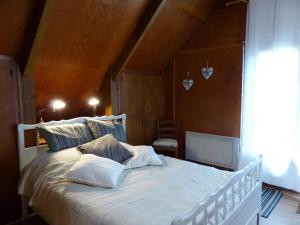 a bedroom with a white bed with a wooden ceiling at Chalet familial au centre équestre près de Vichy, animaux admis - FR-1-489-274 in Le Vernet