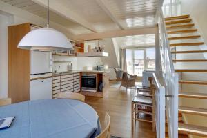 Una cocina y un comedor con una mesa y una escalera. en Unique Holiday Apartment With A View In Skagen, en Skagen