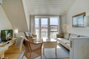 Una sala de estar con un sofá y un televisor. en Unique Holiday Apartment With A View In Skagen, en Skagen