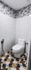 baño con aseo y suelo de mosaico en Amyza Homestay 3Bilik, en Semerah