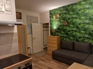 a living room with a couch and a green wall at Müller's 2 Apartment - Self Check In in Zwickau