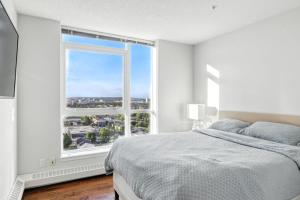 a bedroom with a bed and a large window at 17th Avenue Paranomas Escape in Calgary +33 photos