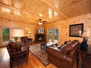 una sala de estar con muebles de cuero en una cabaña de madera en Majestic Views Holiday home, en Gatlinburg