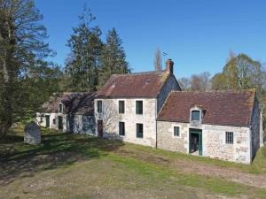 an old stone house on a hill with trees at Maison en pierres avec Grand Jardin, WIFI, tout inclus - FR-1-497-170 in Neuvy-au-Houlme