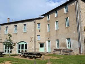 ein großes Backsteingebäude mit Bänken davor in der Unterkunft Grand Gîte à La Chabanne - Jusqu'à 14 pers, Animaux admis, Parking, Wifi - FR-1-489-340 in La Chabanne