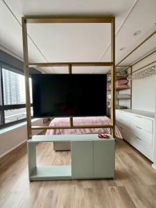 a bedroom with a bunk bed with a flat screen tv at Studio Cute, Parque Una in Pelotas +8 photos