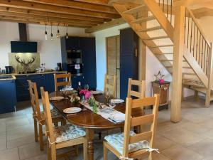 eine Küche und ein Esszimmer mit einem Holztisch und Stühlen in der Unterkunft Maison rénovée en Sologne Bourbonnaise avec Jardin et WiFi - FR-1-489-379 in Saligny-sur-Roudon