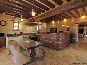 a large kitchen with a wooden table in it at Maison de charme avec piscine intérieure, grand jardin, et paysages magnifiques en pleine campagne - FR-1-497-164 in Rémalard en Perche