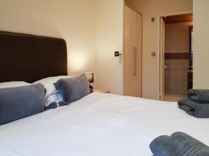a bedroom with a large white bed with blue pillows at Kingfisher Lodge - Uk46046 in Balloch +9 photos