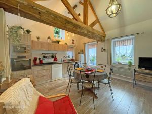 ein Wohnzimmer mit Tisch und Küche in der Unterkunft Charme rustique près de Bagnoles, animaux admis, jardin et WiFi inclus - FR-1-497-222 in La Coulonche