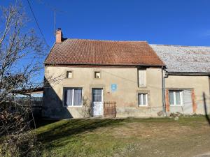an old white house with a brown roof at Gîte indépendant à Saint-Genest avec jardin clos - FR-1-489-562 in Saint-Genest