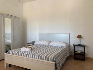 a bedroom with a bed with a striped bedspread at Dream Home in Nardò