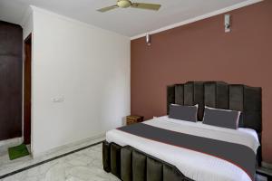 a bedroom with a large bed with a wooden headboard at Hotel O Uk House Residency in Gurgaon +23 photos