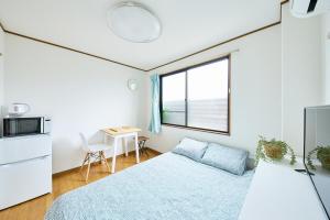 una camera da letto con un letto, una scrivania e una finestra di KYOTO R01 - 10 sec walk-Ryoanji Station a Kyoto