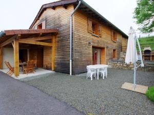 ÉchanssieuxにあるGîte 4 chambres avec jardin, animaux acceptés, terrasse et abri voiture - FR-1-496-17のテーブルと白い傘のある木造の家