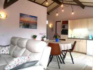 a living room with a couch and a table at Zeepolder I 129 in De Haan
