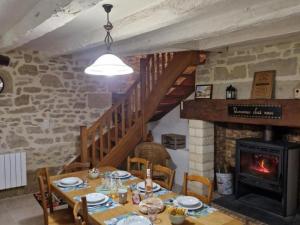 una sala da pranzo con tavolo e camino di Maison familiale avec piscine privée, jeux pour enfants, salle de sport et Wifi en Dordogne - FR-1-616-70 a Cherveix-Cubas