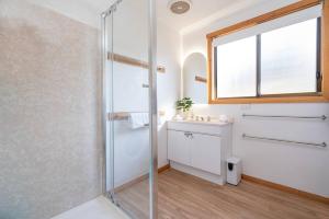 a bathroom with a glass shower and a sink at Tasman Breeze - Beachside Escape near Historic Site in Port Arthur +30 photos