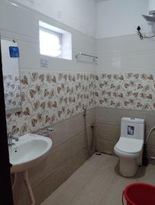 a bathroom with a toilet and a sink at Valley homes in Ooty