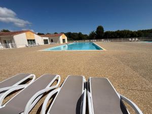 a group of chairs sitting next to a swimming pool at Maison 2 chambres au calme avec piscine, proche plages et commerces - FR-1-197-484 in Talmont-Saint-Hilaire +9 photos
