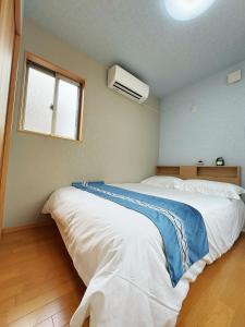 静舍JR难波站徒步8分Jr芦原桥徒步5分梅田心斋桥道顿堀黑门市场关西机场一站直达日式整栋一户建 في أوساكا: غرفة نوم بها سرير أبيض كبير ونافذة