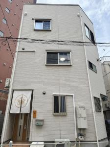 静舍JR难波站徒步8分Jr芦原桥徒步5分梅田心斋桥道顿堀黑门市场关西机场一站直达日式整栋一户建 في أوساكا: مبنى عليه لافتة كرة سلة