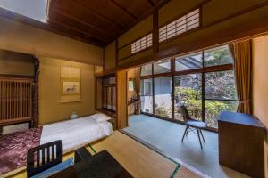 a bedroom with a bed and a desk and a chair at Magma Resort Yamanashi in Minobu