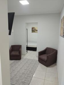 two chairs sitting in a room with a rug at Apartamento loft in Poços de Caldas