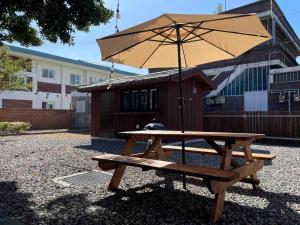 a picnic table with an umbrella next to a building at Private Suncheon House in Suncheon