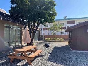 a picnic table with an umbrella next to a building at Private Suncheon House in Suncheon