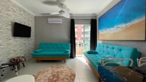 a living room with a blue couch and a tv at Riviera de São Lourenço Boulevard Travel inn in Bertioga
