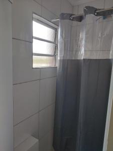 a shower curtain in a bathroom with a window at Apartamento loft in Poços de Caldas +6 photos