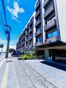 a building with a parking lot in front of it at Flat Beira Mar, Arpoar João Pessoa in João Pessoa