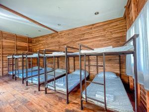 four bunk beds in a room with wooden walls at Kanta Hill Resort in Nakhon Si Thammarat