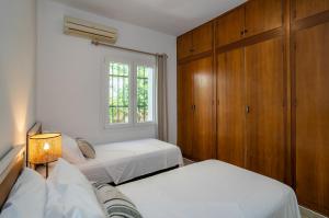 a bedroom with two beds and a window at Charming Malaga Retreat, Main House plus Cozy Casita in Málaga
