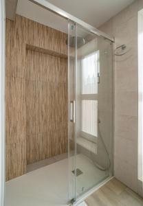 a shower with a glass door in a bathroom at Charming Malaga Retreat, Main House plus Cozy Casita in Málaga