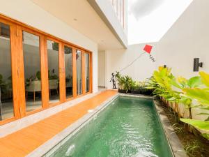 a swimming pool in the middle of a house at KANGIN House Sanur in Ketewel