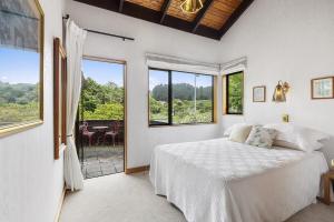 Un dormitorio con una cama y una ventana grande. en Karori park side villa, en Wellington