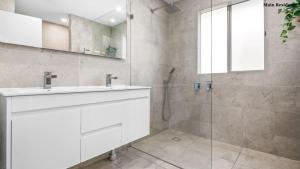 a white bathroom with a sink and a shower at Trio by the Sea in Forster +20 photos