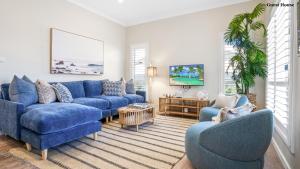 a living room with blue couches and chairs at Trio by the Sea in Forster