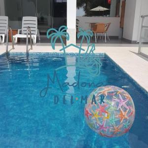 una piscina con una pelota de playa en el agua en Residencia Madona del Mar - Casa Frente al Mar con Piscina, en Zorritos