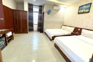 Postel nebo postele na pokoji v ubytování Kim Ngoc Khanh Hotel