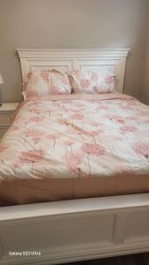 a bed with pink and white sheets and pillows at One bedroom self contain in Prince Albert