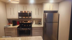 a kitchen with white cabinets and a stainless steel refrigerator at One bedroom self contain in Prince Albert