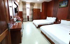 Postel nebo postele na pokoji v ubytování Kim Ngoc Khanh Hotel