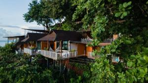 a house on the side of a hill with trees at Chareena Hill Beach Resort in Ko Lipe