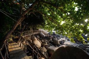 eine Brücke über einen Steinhaufen an einem Strand in der Unterkunft Chareena Hill Beach Resort in Ko Lipe