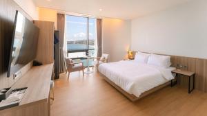a hotel room with a bed and a flat screen tv at The Van Hotel in Ulsan